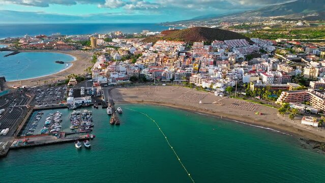 Aerial view of  Port of Los Cristianos, Marina with cruise ships and boats in Tenerife. View from above of tourist resorts and colourful houses in the Canary Islands, Spain.