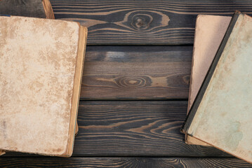 Old vintage books on the retro style wooden table top view background with copy space.