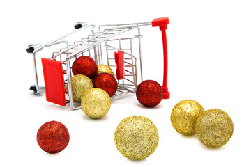 Overturned supermarket grocery shopping cart with scattered Christmas tree toys isolated on white...