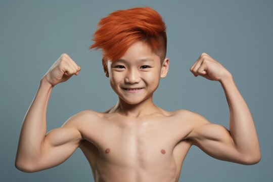 A young boy with an orange mohawk hairstyle poses for a picture. This image can be used for various purposes