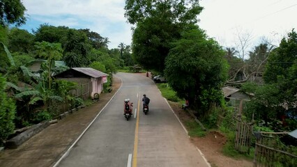 Girls on motorbike throw up "peace sign" as the pass another rider 