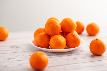 Mandarins on a plate against a bright backdrop, emphasizing the fruit's health benefits
