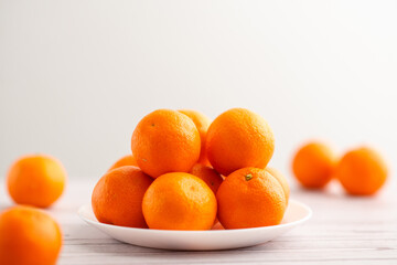 Mandarins on a plate against a light backdrop, a fresh perspective on fruit goodness