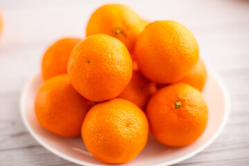 Plate of mandarins on a bright background, showcasing the nutritional value of citrus fruits
