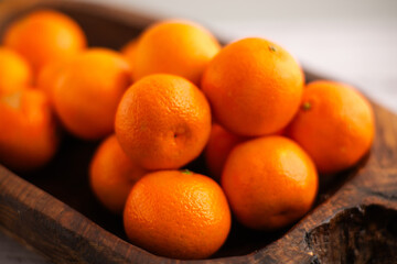 Citrus bounty: Mandarins resting in a wooden dish, a vitamin-packed tribute to the benefits of citrus