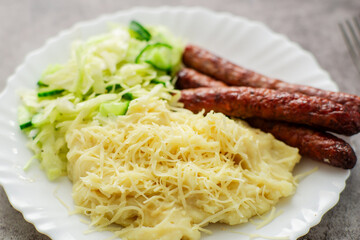 A plate filled with creamy mashed potatoes infused with cheese, a refreshing cabbage-cucumber...