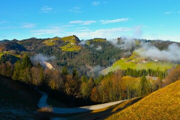 Fototapeta na wymiar Polhograjski Dolomiti hills covered in forest and meadow with farm buildings in Slovenia