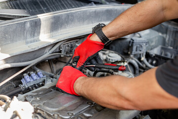 Car repairs. An auto mechanic unscrews the gas distribution mechanism cover with a ratchet wrench