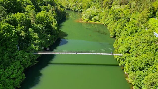 Drone view Rope Bridge over Pasarel dam, water reflection, autumn trees and a fisherman
