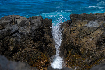 Fototapeta na wymiar Beautiful landscape with deep blue water. Powerful waves crash against black volcanic rocks on the coast of ´Aguas Verdes, Fuerteventura island.