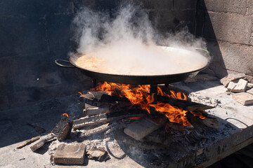 Paella, a traditional and famous Valencian food cooked with wood - 696551526