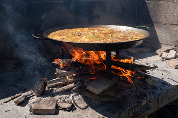 Paella, a traditional and famous Valencian food cooked with wood - 696551530