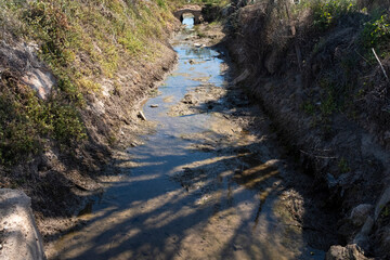 Ditch. Irrigation channel with water residues. - 696551550