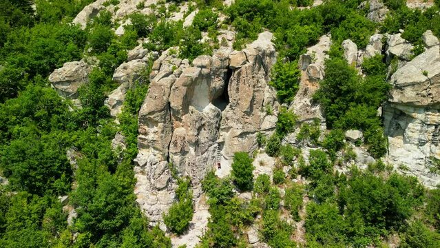Drone view over Ancient Thracian sanctuary - Utroba cave above Kardzhali dam. Entrance to a cave in the form of a narrow slit through which a panoramic view can be seen