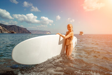 Woman sup sea travel in black bikini. Portrait of a happy girl on the background of a surfboard in...