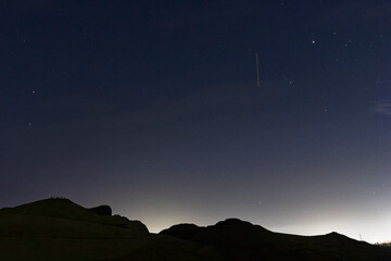 Northumberland night sky over Northumberlandia with stars, cloud and light pollution.