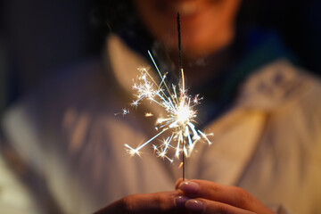 woman holding burning sparkler during Christmas