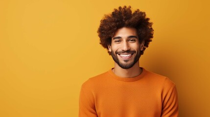 Fototapeta na wymiar Portrait of handsome cheerful man with curly hair smiles toothily poses happy against brown background dressed casually isolated over brown background. Positive human emotions