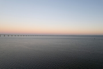 sunset over the ocean and second longest in europe bridge vasco da gama in lisbon portugal
