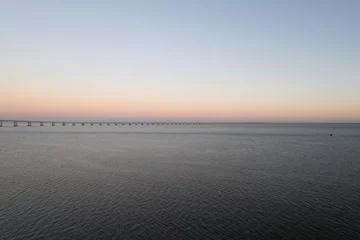 Photo sur Plexiglas Pont Vasco da Gama sunset over the ocean and second longest in europe bridge vasco da gama in lisbon portugal