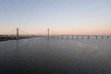 sunset over the ocean and second longest in europe bridge vasco da gama in lisbon portugal