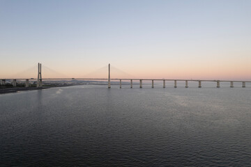 Fototapeta na wymiar sunset over the ocean and second longest in europe bridge vasco da gama in lisbon portugal