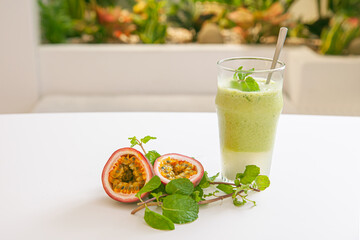Vegetarian passion fruit and mint leaves smoothie in glass isolated on white background