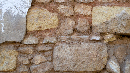 An old ruined wall of stones and bricks.Suitable for backgrounds.