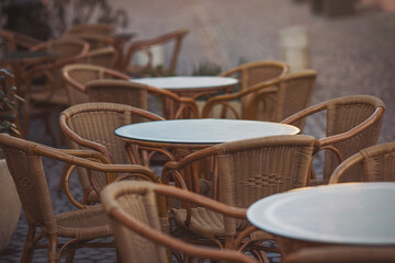 Coffeehouse cafe restaurant terrace. Wooden chairs and tables. Outdoor terrace concept. Shallow focus. Copy space. Old fashioned empty cafe terrace with vintage chairs and tables. Loft style cafe.