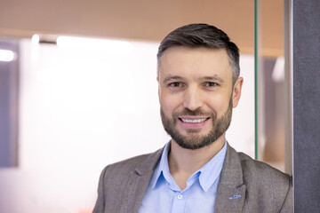Close-up portrait of mature successful businessman, man smiling and looking at camera inside office building at workplace, satisfied bank investor boss.