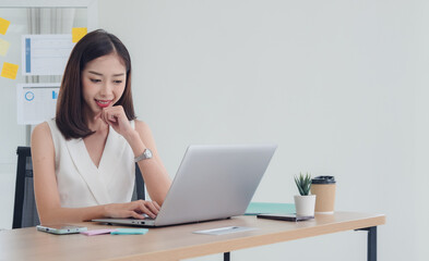 Portrait woman girl Asian one person wearing white dress pretty smile sitting chair on desk looking notebook ready for business service call center working job online sale inside the room office