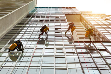 Industrial mountaineering workers hangs over residential facade building