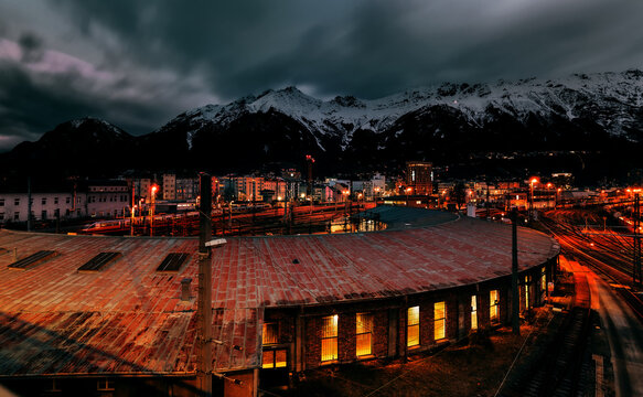 view of the railway station at night with the Alps in the background.