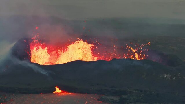 Aerial drone view over active volcanic crater eruption. Hot lava and magma coming out of the crater. Tourist attraction in Iceland Litli-Hr&uacute;tur eruption 2023. Beautiful and dangerous disaster.