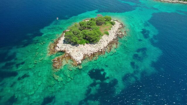 Aerial view of a small uninhabited island with crystal clear sea water