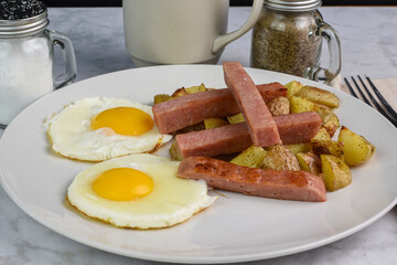 fried eggs with spam sticks and  home fries