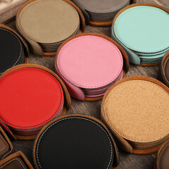 Leather table mats in different colors. Concept shot, top view. Custom background view of leather table coaster. Stitched and leather table coaster