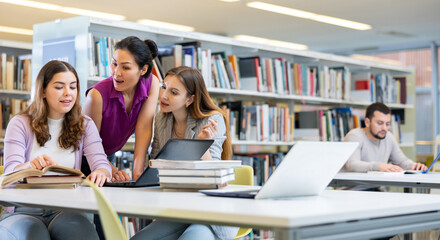 Three young women preparing for exams together in a public library