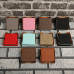 Leather table mats in different colors. Concept shot, top view. Custom background view of leather table coaster. Stitched and leather table coaster