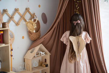 girl with angel wings plays in a beautiful children's room