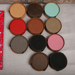 Leather table mats in different colors. Concept shot, top view. Custom background view of leather table coaster. Stitched and leather table coaster