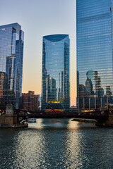 Chicago canal at dawn with light reflecting blue off skyscraper windows and waterway, tourism USA