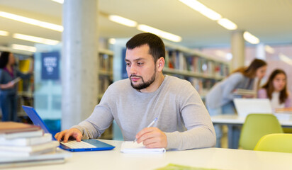 Portrait of man working at a computer in a public library