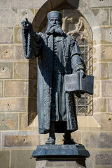 Statue of Johannes Honterus pointing towards  Johannes Honterus highschool