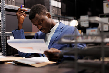 Corporate employee analyzing bookkeeping report, checking administrative record. African american...