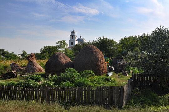 Haystacks and church in Letea village. Danube Delta, Romania