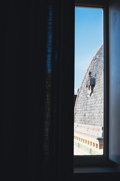 Black roof tiles on an ancient building seen from a window in Narbone, France