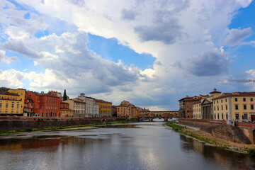 Häuser am Arno und Ponte Vecchio unter malerischen Wolken in Florenz