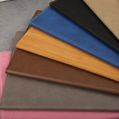 Leather portfolio. Concept shot, top view, portfolio in different colors and leather pen. Custom background flap portfolio view. Portfolio and accessories.