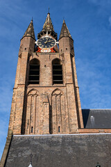 Fototapeta na wymiar Old Church (Oude Kerk, was founded in 1246) is a Gothic Protestant church in Delft, Netherlands. Its most recognizable feature is a 75-meter-high brick tower that leans about two meters from vertical.